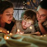 Family reading a book at night