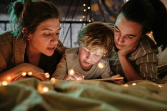 Family reading a book at night