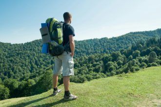 Traveler with backpack in the Carpathian mountains in summer