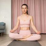 Young brunette woman with eyes closed practicing breathing exercise.