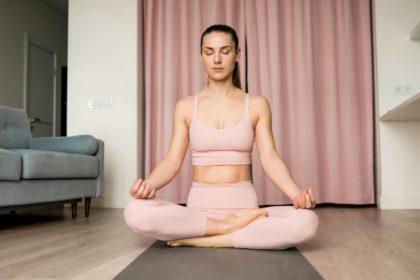 Young brunette woman with eyes closed practicing breathing exercise.