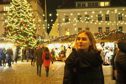 Young woman walking around the Christmas fair on a winter evening