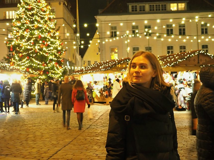 Young woman walking around the Christmas fair on a winter evening